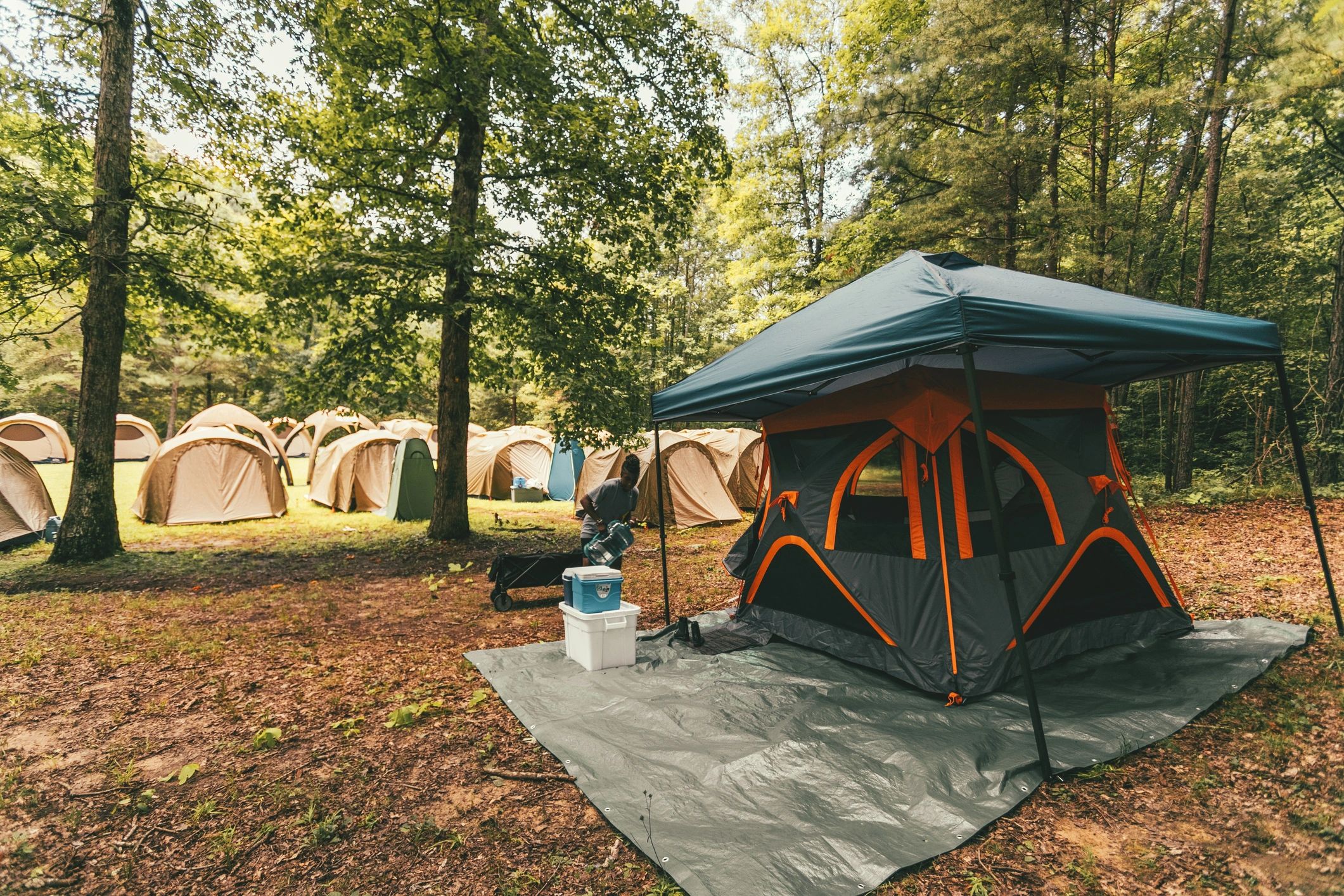 Person setting up camping equipment at a campsite