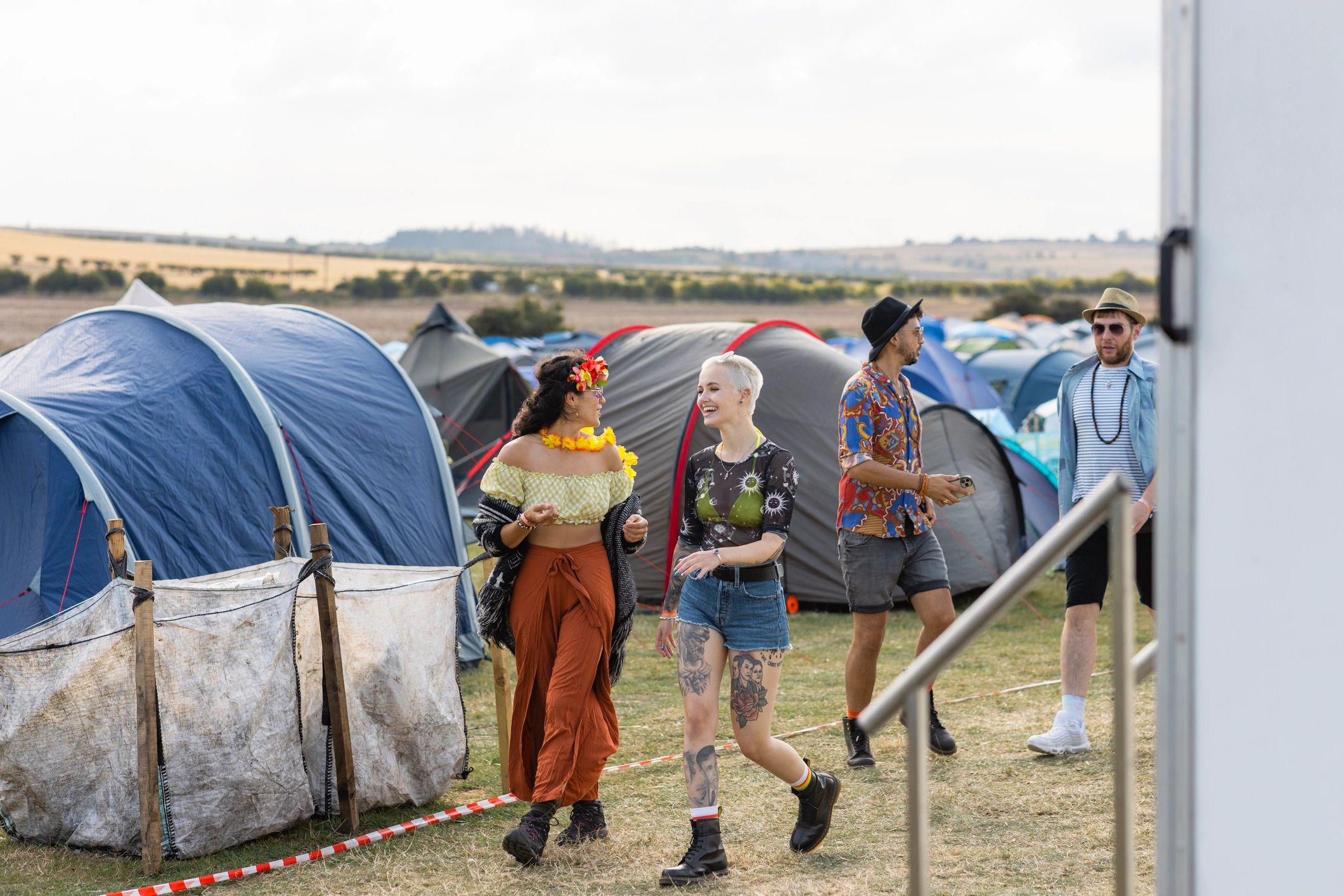 Community members walking past a campsite with outdoor gear