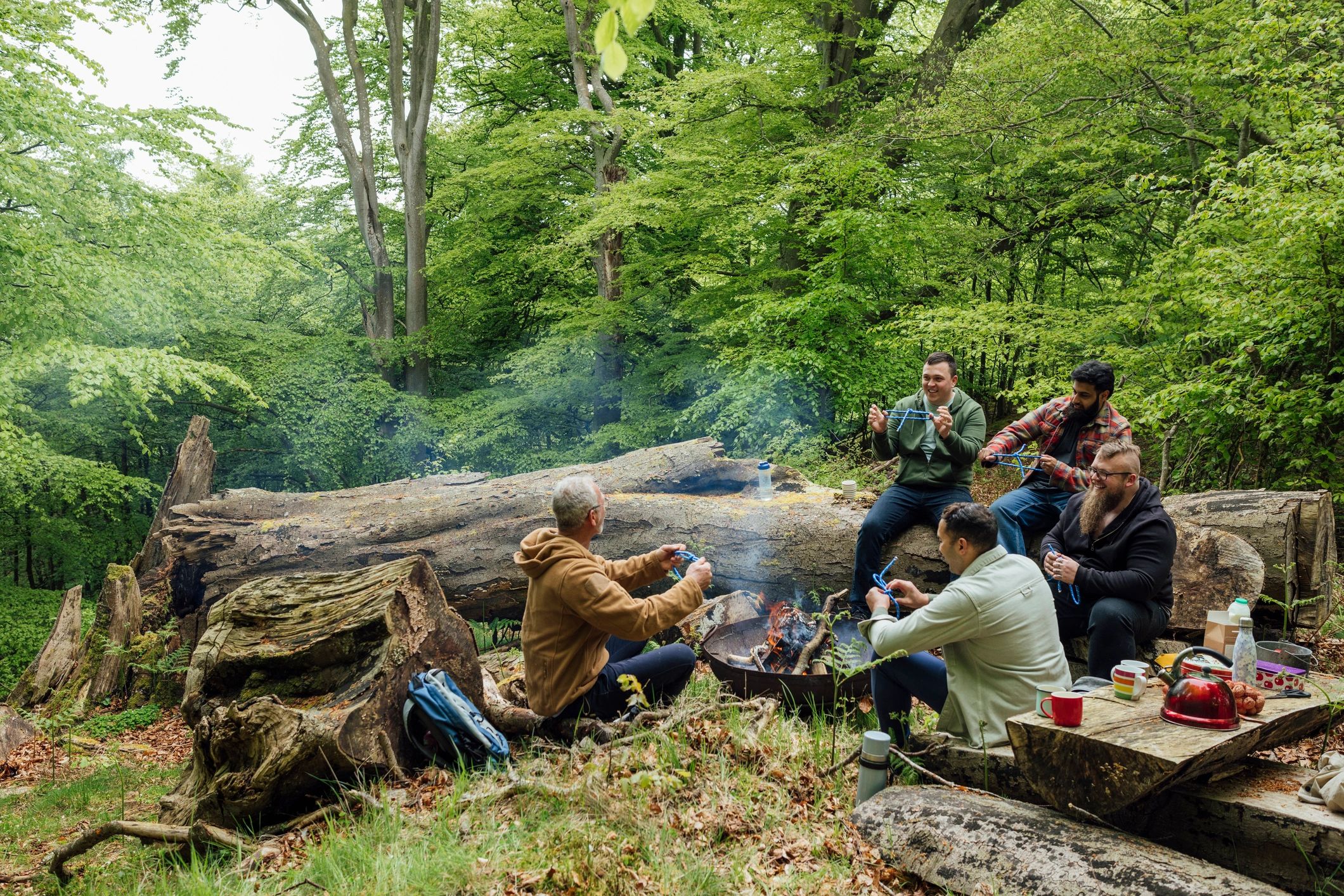 Group learning outdoor skills around a fire pit